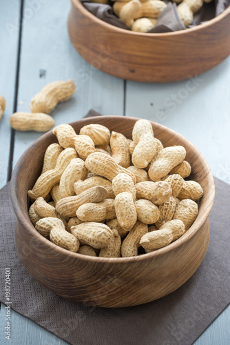 peanuts in cup. A bowl of peanuts in wood background