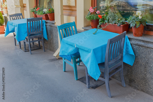 Tables of a street cafe with a blue tablecloth. City