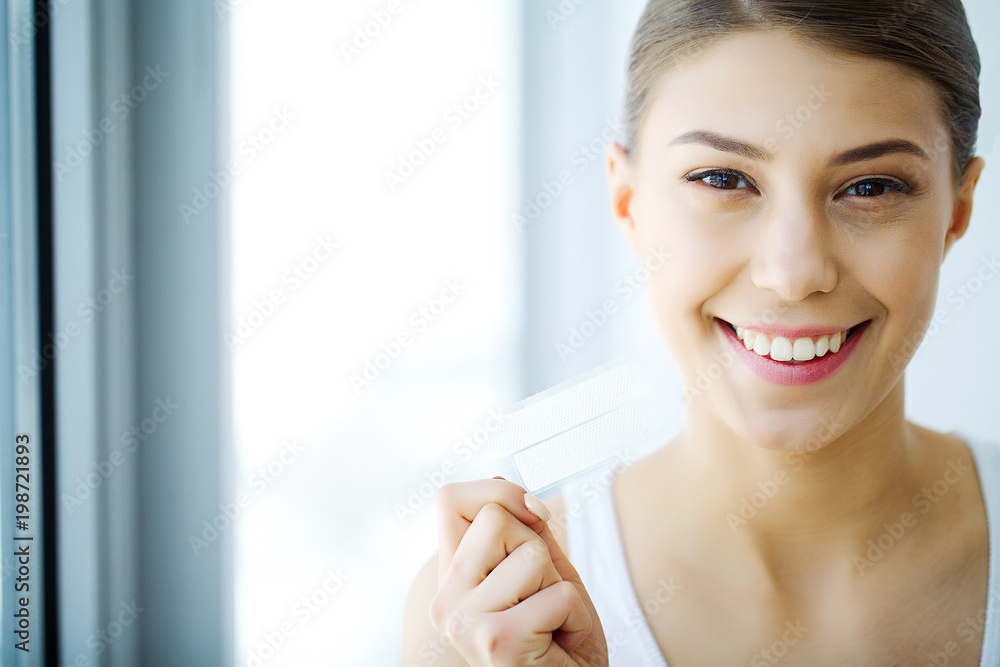 Teeth Whitening. Beautiful Smiling Woman Holding Whitening Strip. High Resolution Image Teeth Whitening. Beautiful Smiling Woman Holding Whitening Strip. High Resolution Image