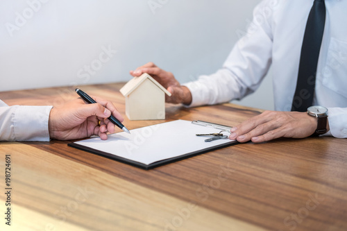 Confident man signing contract of loan agreement document with broker agent, Real Estate concept © Freedomz