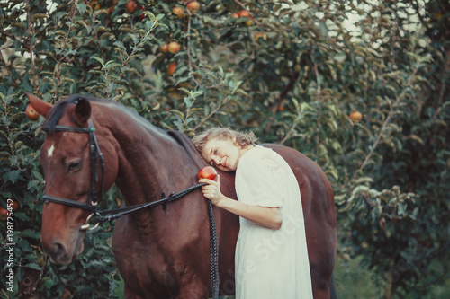 A woman feeds a horse