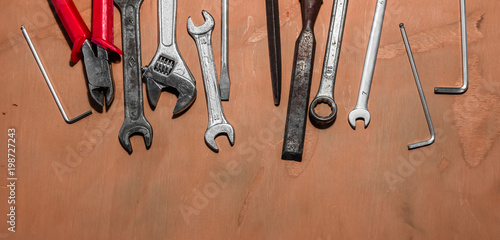 Older tools are laid out in a row on background of the old wooden floor.