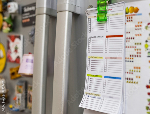 Fototapeta Naklejka Na Ścianę i Meble -  close-up of shopping list hanging on the fridge