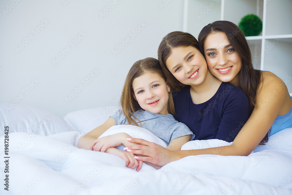 Happy family on the bed. Children with their mother in the bedroom. Happy family on the bed. Children with their mother in the bedroom.