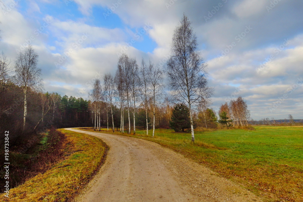 Autumn landscape with unpaved road and clouds Autumn landscape with unpaved road and clouds