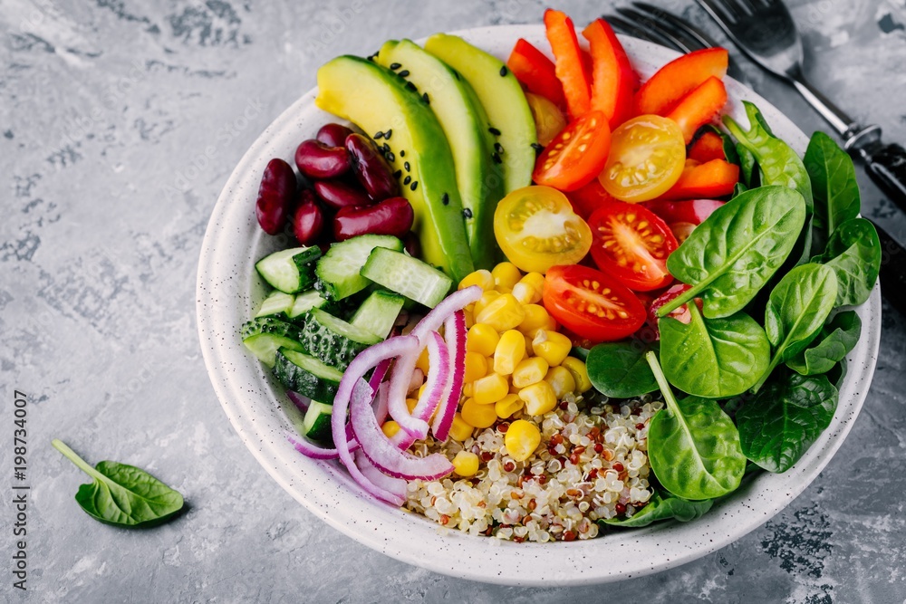 Healthy vegan lunch Buddha bowl. Avocado, quinoa, tomato, cucumber, red beans, spinach, red onion and red paprika vegetables salad. Healthy vegan lunch Buddha bowl. Avocado, quinoa, tomato, cucumber, red beans, spinach, red onion and red paprika vegetables salad.