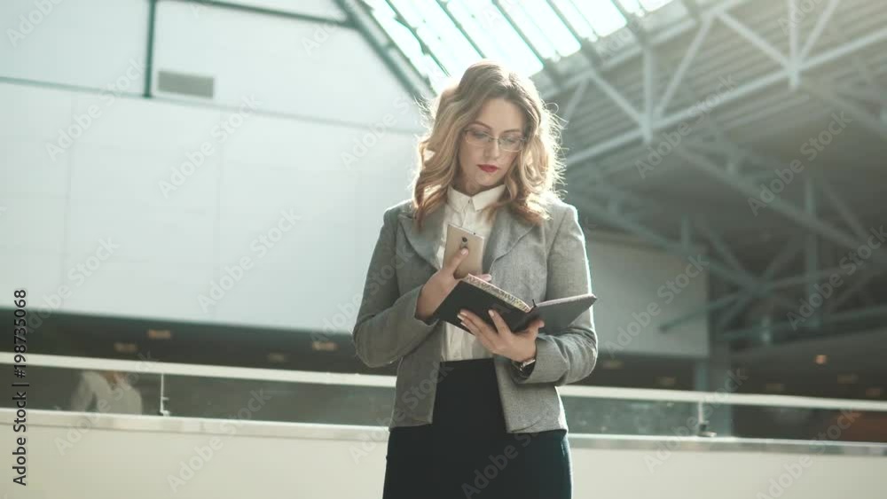 business woman synchronizes notes from notepad on her smartphone business woman synchronizes notes from notepad on her smartphone