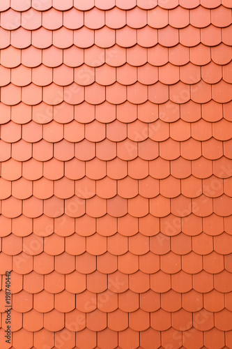 Fragment of a red roof of a private house made of shingles
