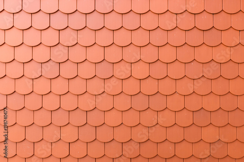Fragment of a red roof of a private house made of shingles