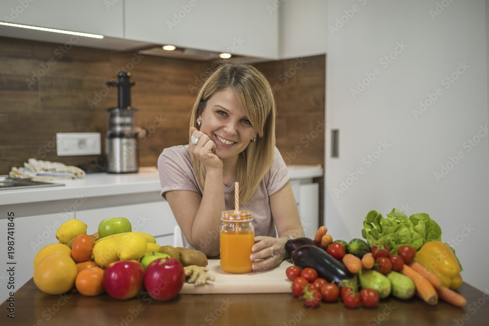 Young woman drinking smoothie in the kitchen