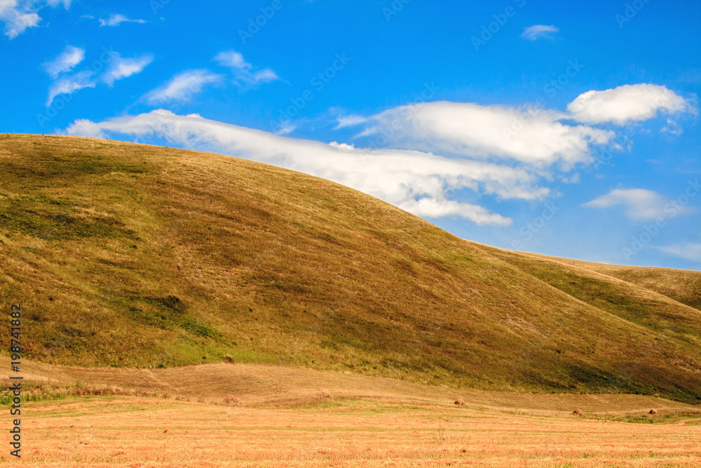 curving wave of a yellow hill against a blue sky, Bashkiria, Russia