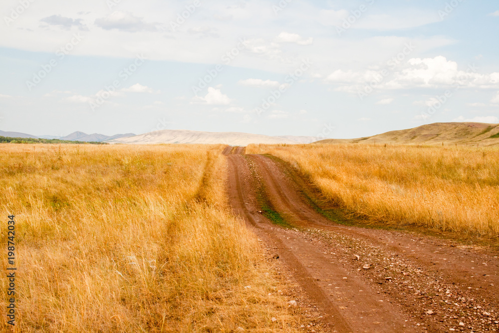 Dirt road in the steppe, hilly area