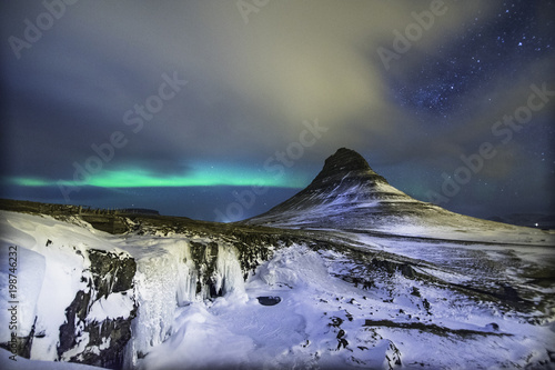 Colorful Aurora Borealis or better known as The Northern Lights and winter milky way over Kirkjufell, Iceland with starry night milkyway.