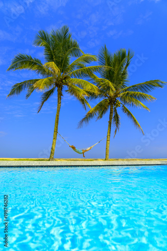 Fototapeta Naklejka Na Ścianę i Meble -  swimming pool and the blue sea with palmcoconut trees