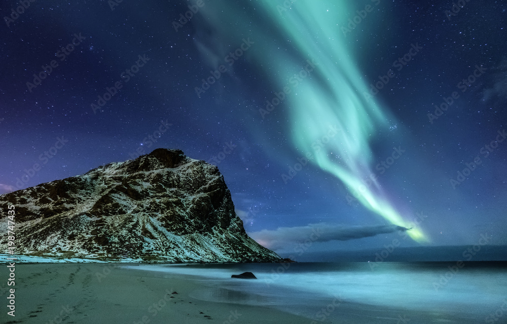 Northen light under mountains and ocean. Beautiful natural landscape in the Norway