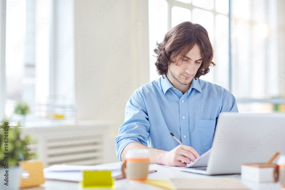 Businessman sitting at his workplace and working with documents Businessman sitting at his workplace and working with documents
