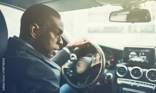 Young African businessman driving through city traffic