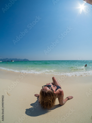 woman sunbathing lying down on the tropical beach