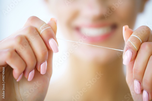 Teeth Care. Beautiful Smiling Woman Flossing Healthy White Teeth. High Resolution Image