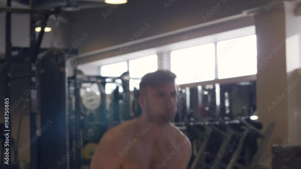Muscular man lifting weight on training. Sweating man doing crossfit exercise Muscular man lifting weight on training. Sweating man doing crossfit exercise