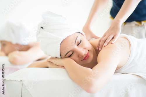 Young woman lying down on massage beds at Asian luxury spa ,Healthy and vacation concept.
