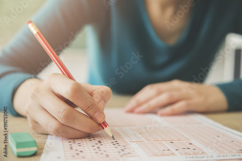 Female student holding pencil and examination paper photo