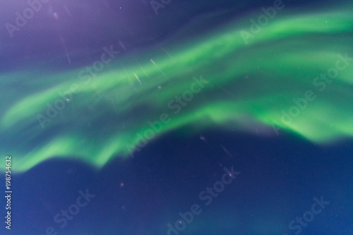 Amazing vivid green Aurora Borealis in moonlight sky with lens flare