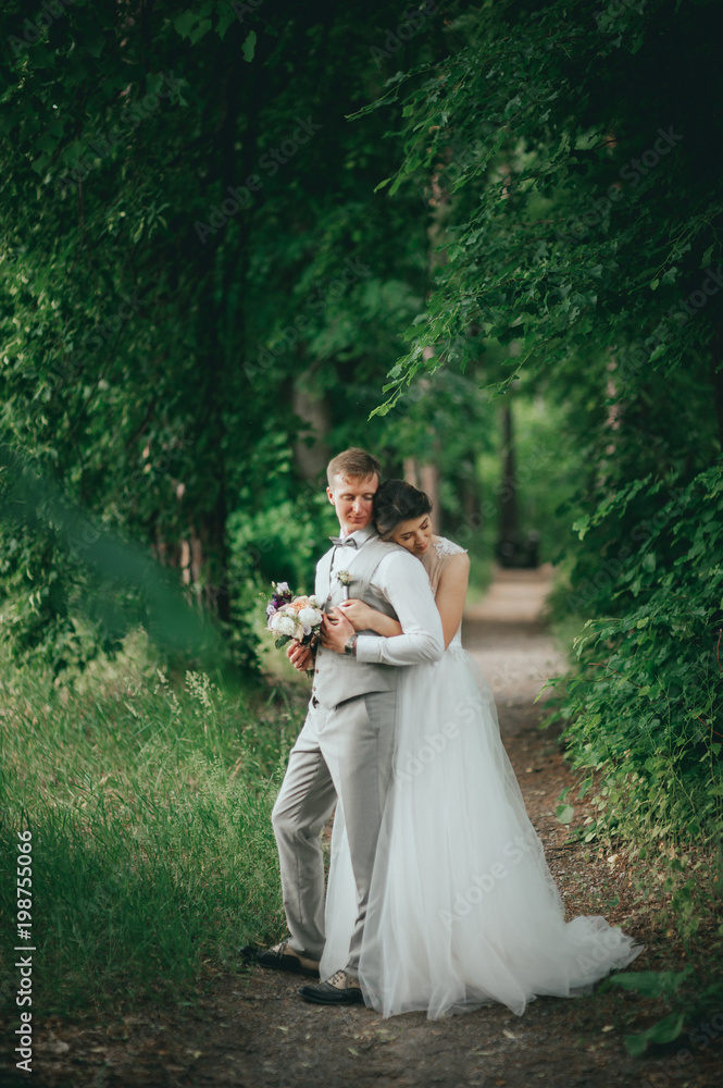 Elegant stylish happy brunette bride and gorgeous groom on the background of a beautiful river in the mountains