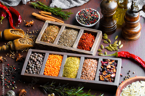 Spices for cooking with kitchen accessories on an old background