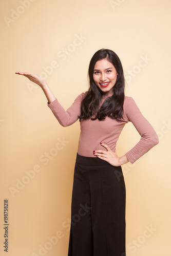 Young Asian woman present with her hand.