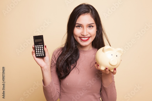 Asian woman thumbs up with calculator.