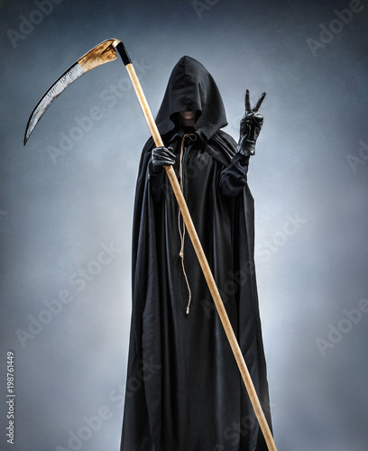 Grim Reaper showing Victory sign. Photo of silhouette grim reaper showing Victory gesture or two finger. Death