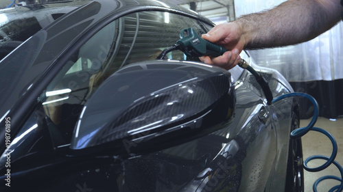 The specialist dries the car from moisture, car washing.