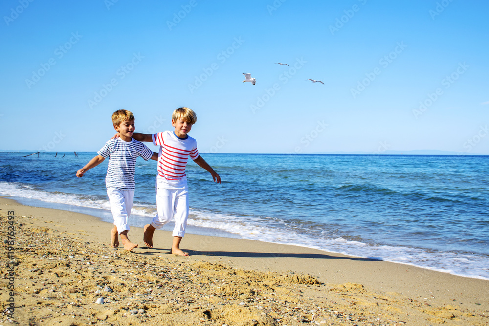 Two happy little boy  running at beach