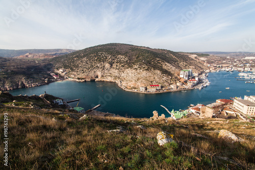 Fototapeta Naklejka Na Ścianę i Meble -  Beautiful view of the Black Sea and the city Balaklava. Balaklava Bay. Clear sunny day and a top view of the port, Crimea