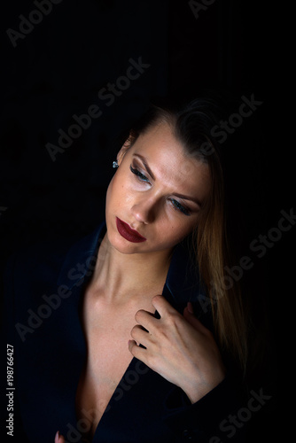 Sexy young blonde with red lips on a black background © Sergey