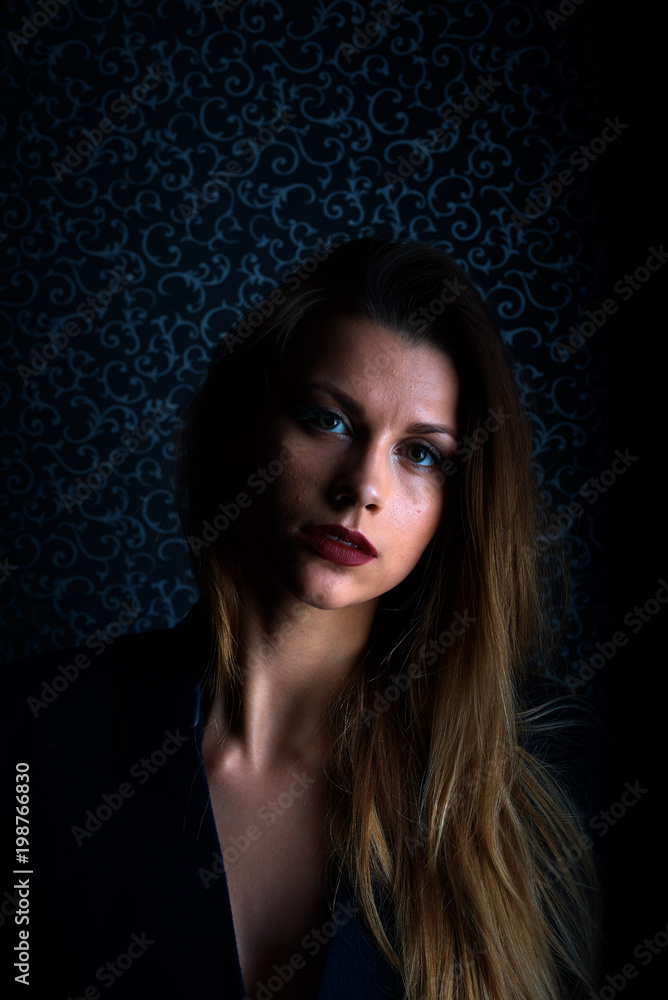 Fototapeta premium Sexy young blonde with red lips on a black background