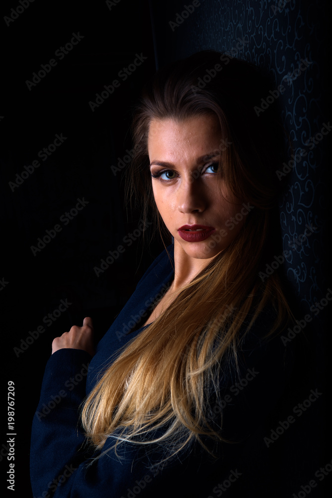 Fototapeta premium Sexy young blonde with red lips on a black background