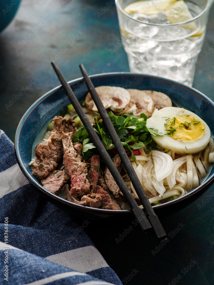 Asian ramen soup with beef, egg, chives and mushrooms in bowl. Asian ramen soup with beef, egg, chives and mushrooms in bowl.