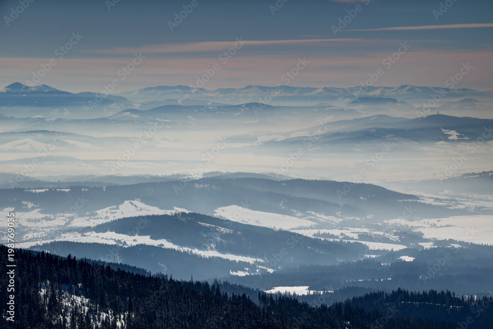 Winter scenery with sunlit blue ridges and valleys filled with fog in Orava and Liptov regions from Babia hora peak, Oravska Magura Chocske vrchy Zapadne and Nizke Tatry ranges Slovakia Central Europe Winter scenery with sunlit blue ridges and valleys filled with fog in Orava and Liptov regions from Babia hora peak, Oravska Magura Chocske vrchy Zapadne and Nizke Tatry ranges Slovakia Central Europe