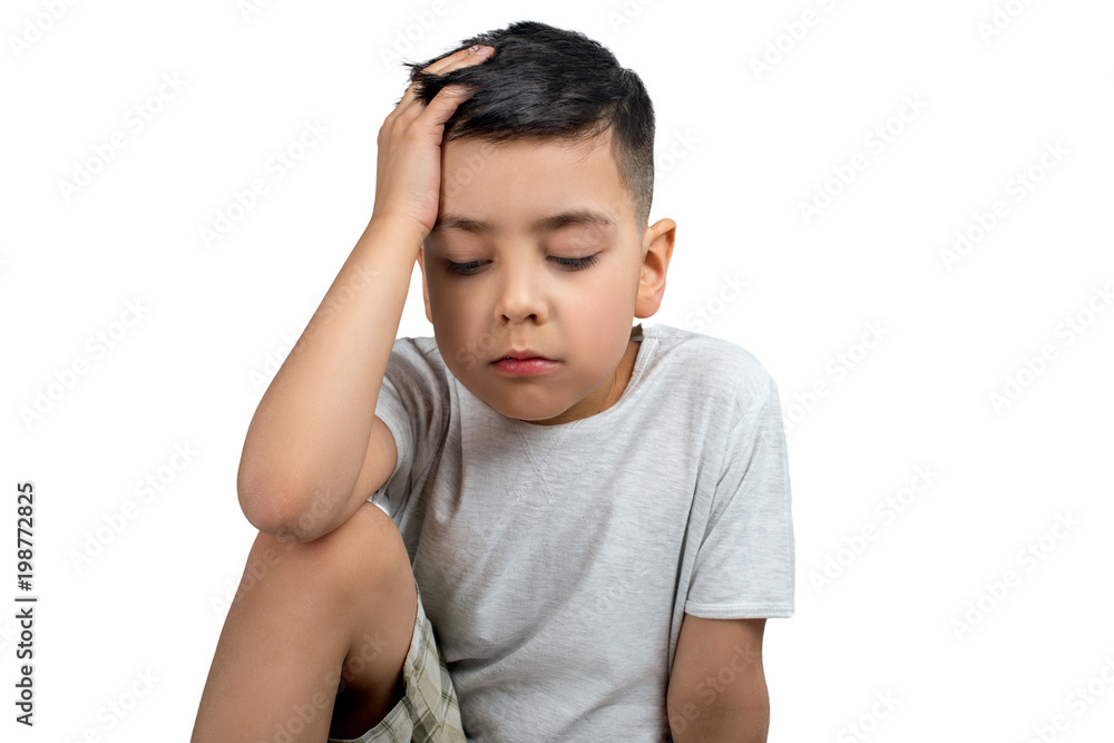 Close up portrait of the sading of the little lboy of the brunette wearing grey t-shirt on a white background with copy space in studio. Close up portrait of the sading of the little lboy of the brunette wearing grey t-shirt on a white background with copy space in studio.