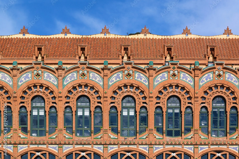 Fototapeta premium Ornated arches on a Modernism facade in Barcelona against a blue sky. Empty copy space for Editor's text.