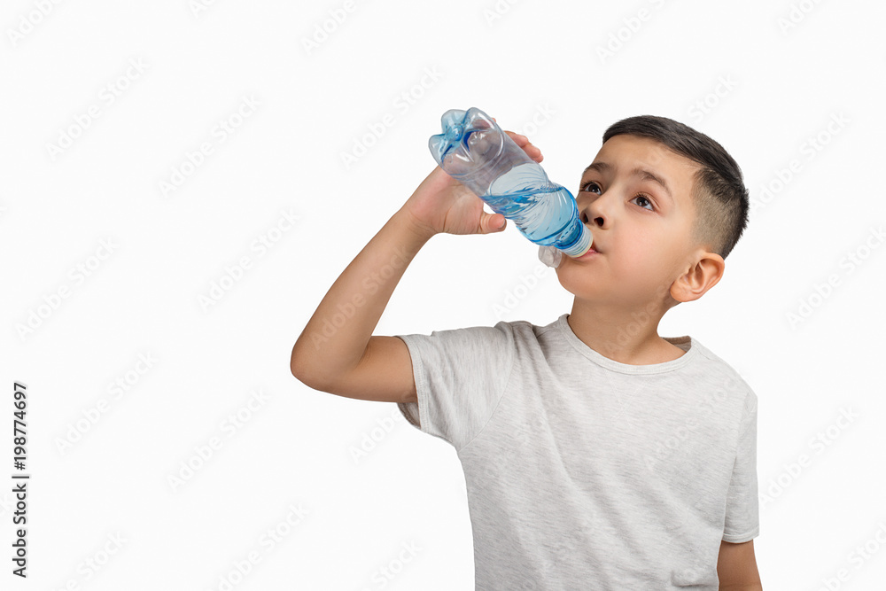 The little boy drinks water from a small plastic bottle on a white  background with copy space in studio. Stock Photo | Adobe Stock