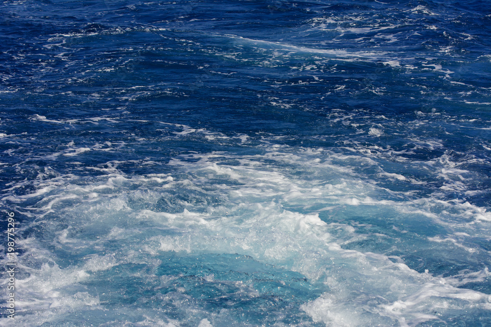 Turbulence made by the foam of sea water from a high-speed yacht on the surface of the sea. Image for background, wallpaper or desktop, abstract texture