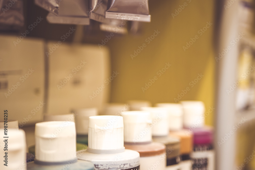shelf with draw paint cans standing in a raw