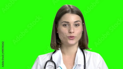 Young cute female doctor talking. Physcician woman's face. Green screen hromakey background for keying. photo