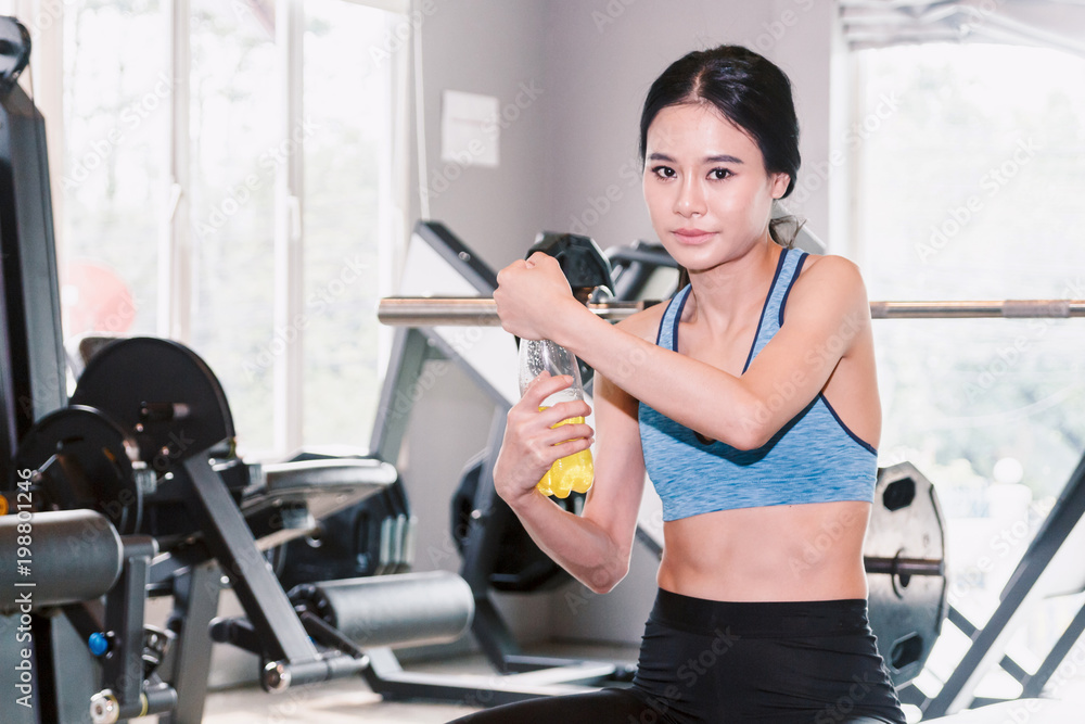 Fototapeta premium Sporty woman holdind energy drink bottle at the gym.fitness and lifestyle concept