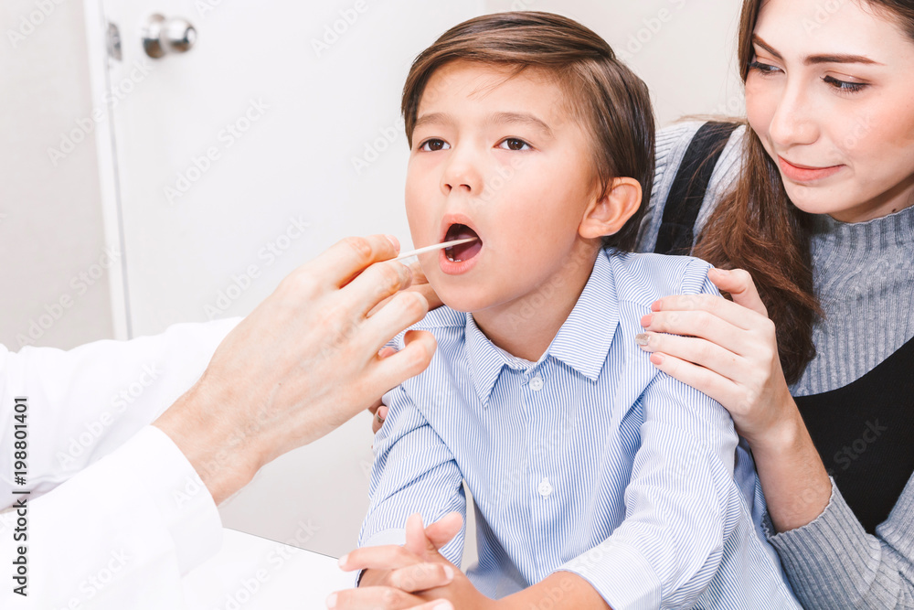 Doctor having throat examined checking little boy in hospital.healthcare and medicine Doctor having throat examined checking little boy in hospital.healthcare and medicine