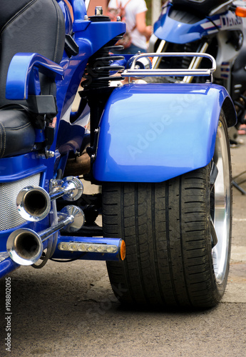 rear side of a blue motorcycle. lovely detail shot of lights and shiny exhaust pipes