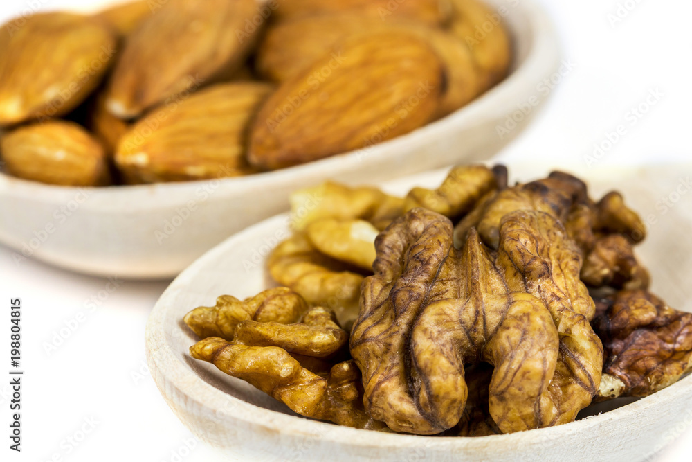 Vegetarian healthy food, almonds and walnuts on a spoon isolated on white Vegetarian healthy food, almonds and walnuts on a spoon isolated on white